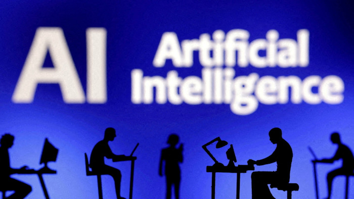 An illustration showing silhouetted figurines using computers and smartphones in front of the words ‘Artificial Intelligence AI’