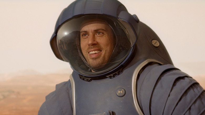 Toby Kebbell's Miles Dale smirking in a blue spacesuit on For All Mankind