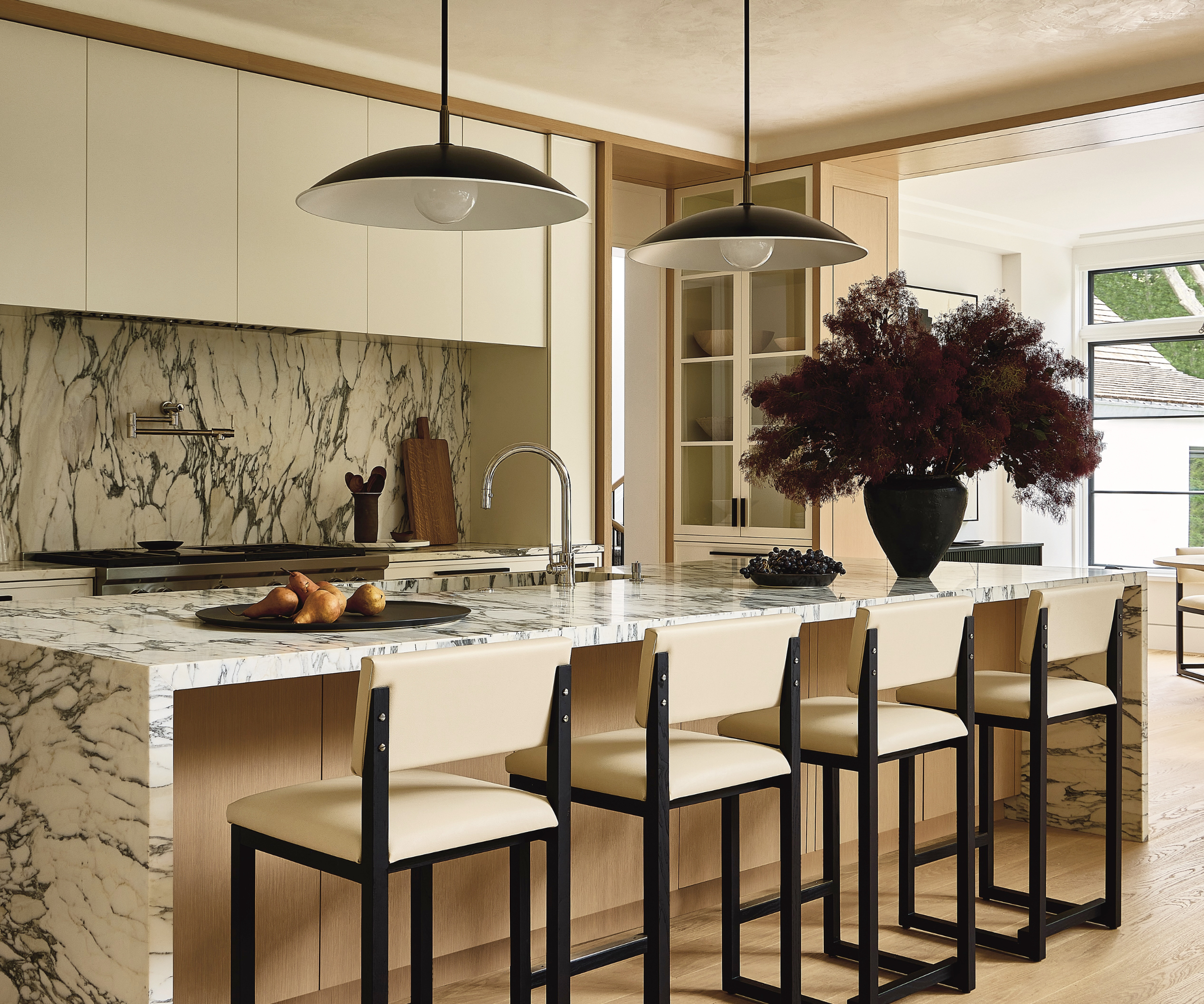 A neutral-toned kitchen with counter chairs.