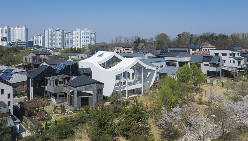 curved eave roofs shape IROJE KHM’s white lakeside residence in south korea