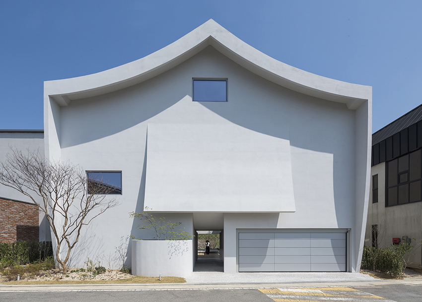 curved eave roofs shape IROJE KHM’s white lakeside residence in south korea