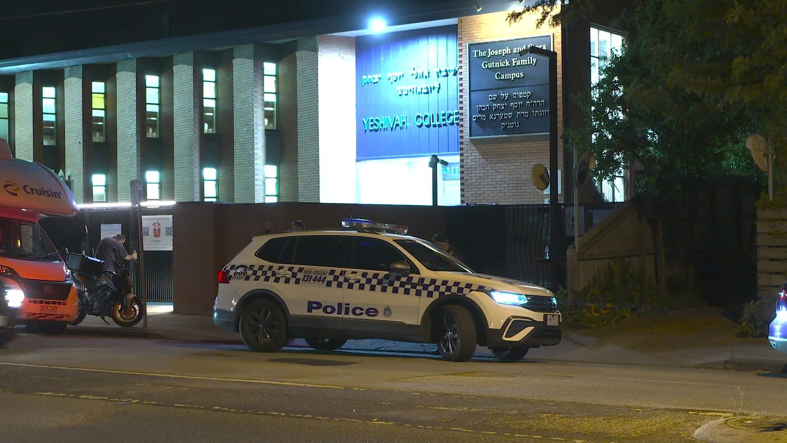 A police car outside of a hebrew building 