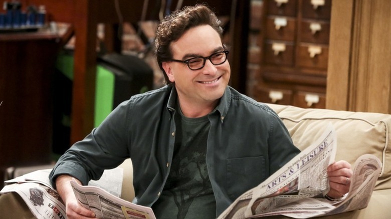 Leonard holding a newspaper and smiling on The Big Bang Theory