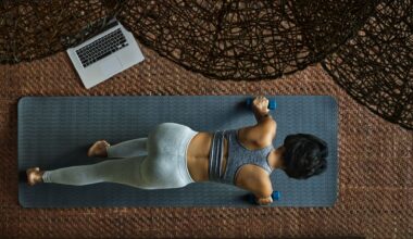 Woman doing 20-minute workout on yoga mat in living room next to open laptop