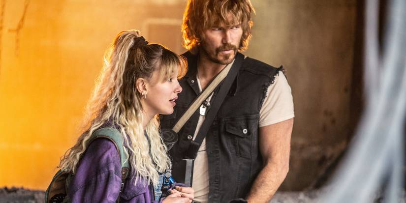 Millie Bobby Brown as Michelle and Chris Pratt as Keats looking at something offscreen in The Electric State.