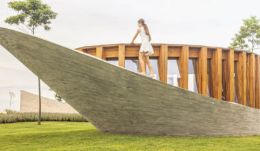 curving concrete walls encircle nest chapel’s timber core in são paulo