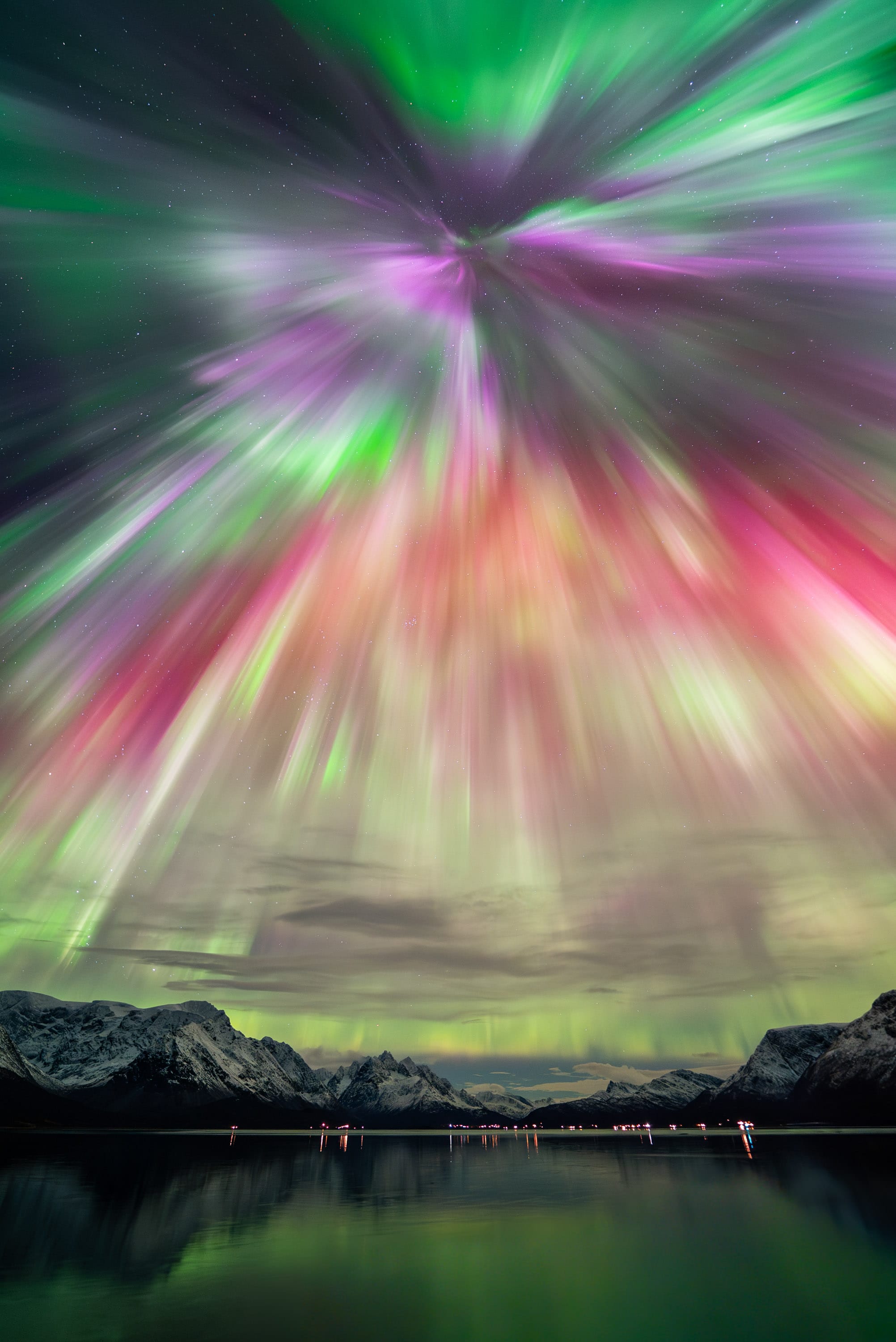 A colorful aurora borealis captured over a rocky landscape