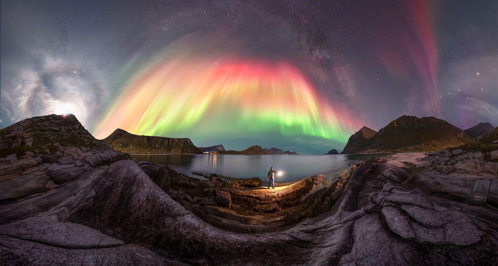 A colorful aurora borealis captured over a rocky landscape