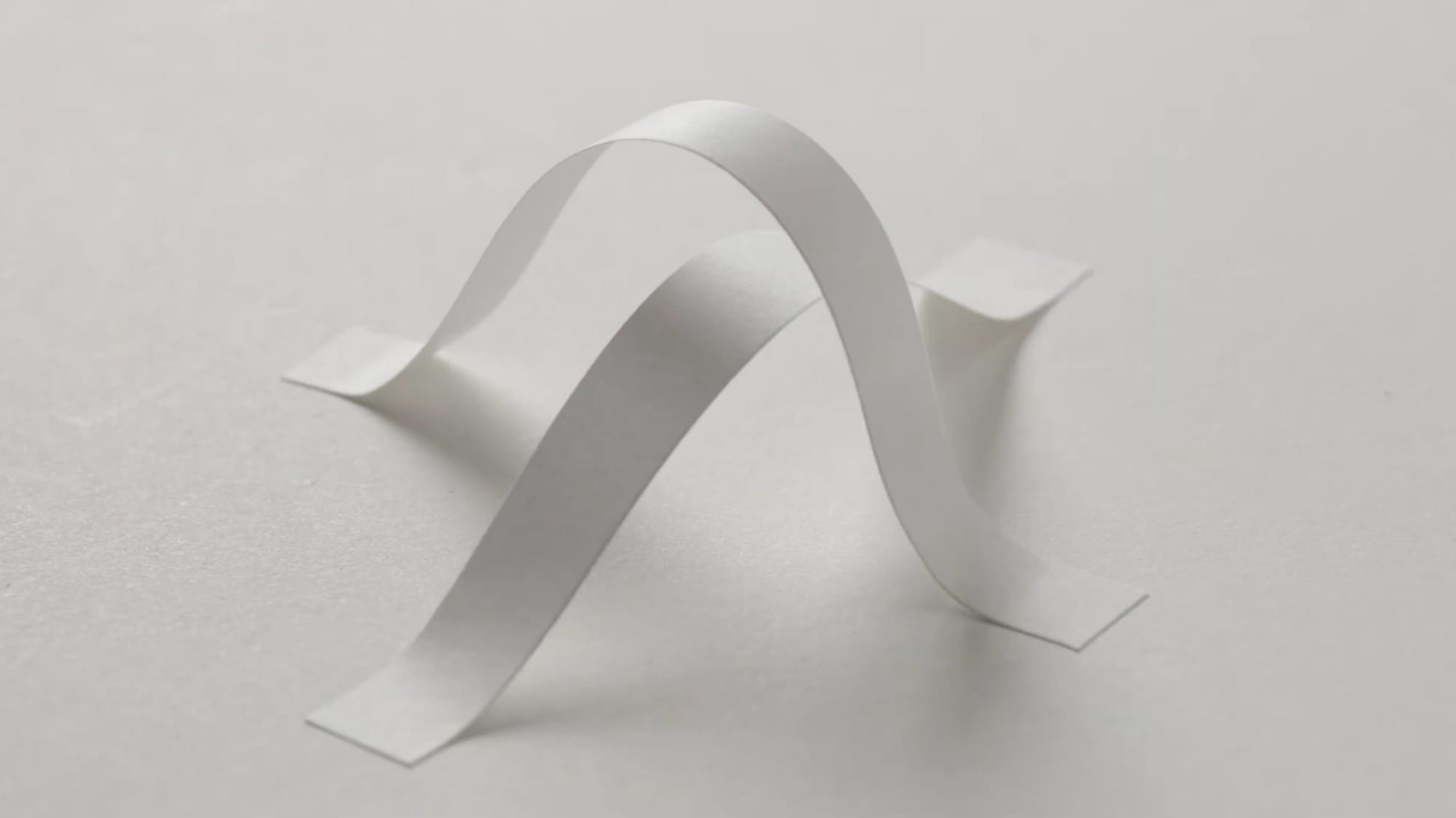 A still from a video of animations made from white pieces of paper in different cut shapes and arrangements