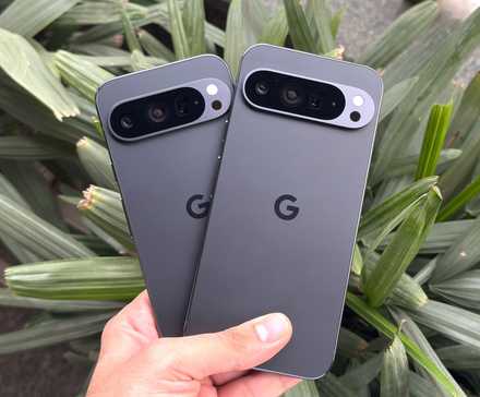 A hand holding the Google Pixel 9 Pro and the Google Pixel 9 XL, comparing the sizes of the two phones