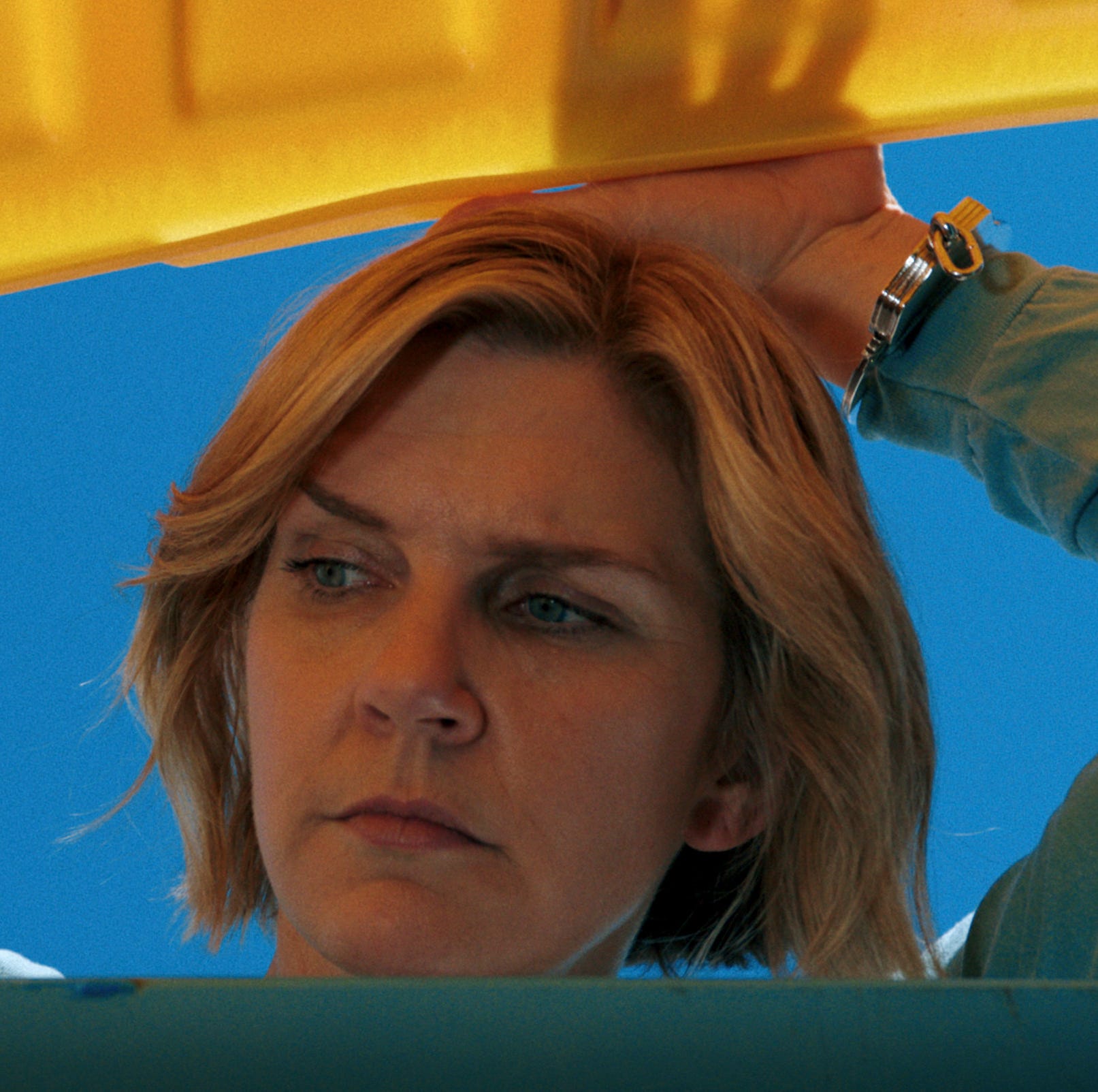 holding a large yellow object against a clear blue sky