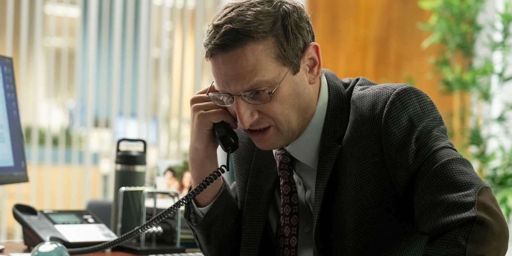 Ron looking distressed on the phone in The Chair Company