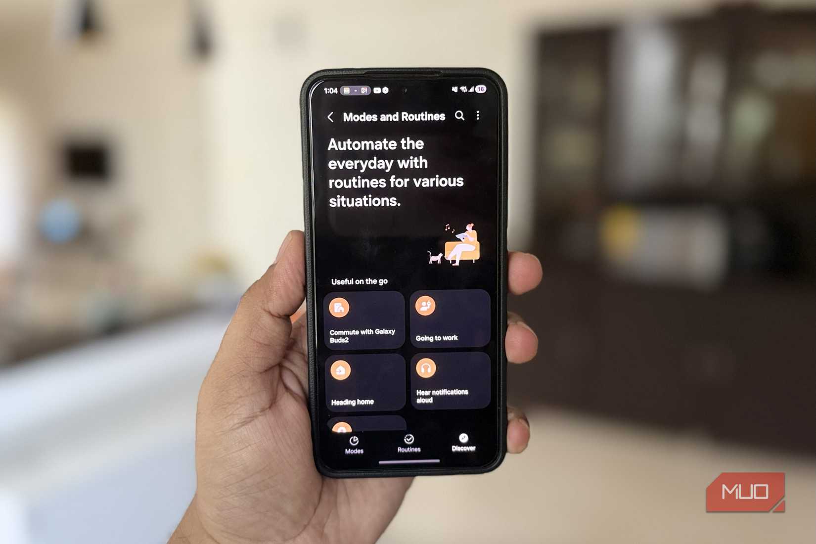 Samsung phone in hand showing modes and routines menu