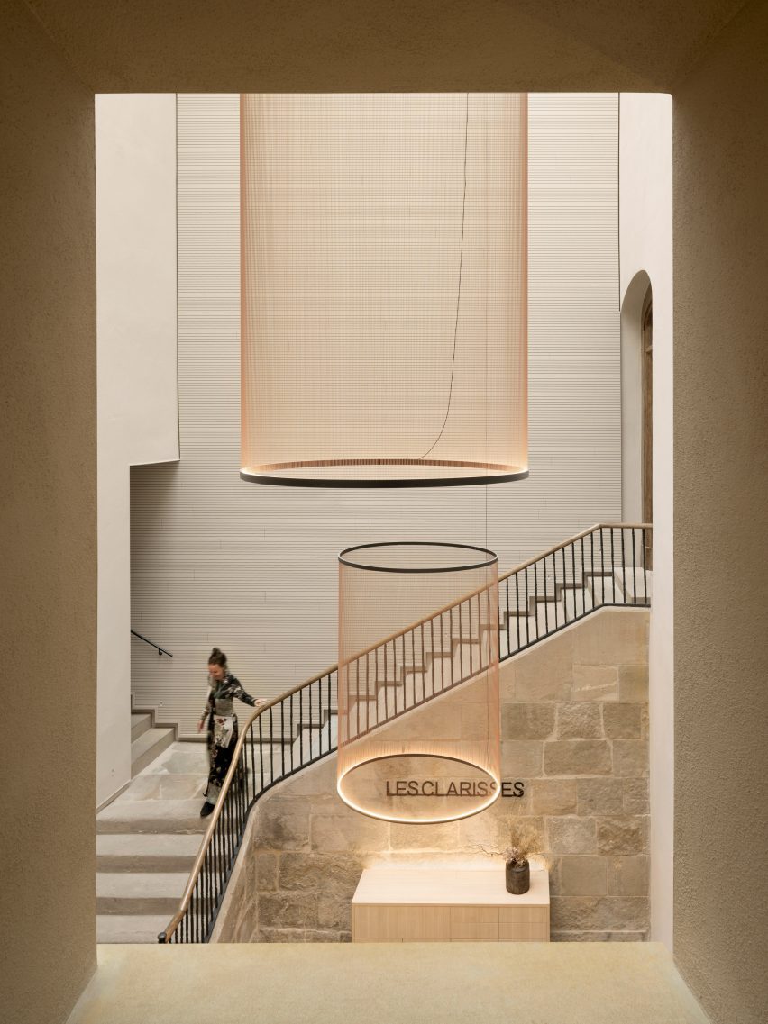 High-ceilinged hotel foyer with statement pendant lights hanging