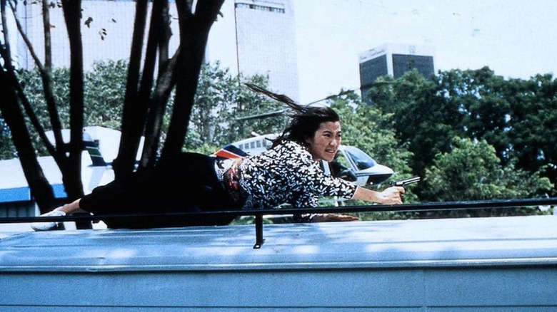 Yang Chien-Hua (Michelle Yeoh) clings to the top of a bus in Supercop