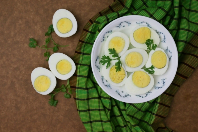 Sliced boiled eggs on a white plate. Illustration photo by Unsplash