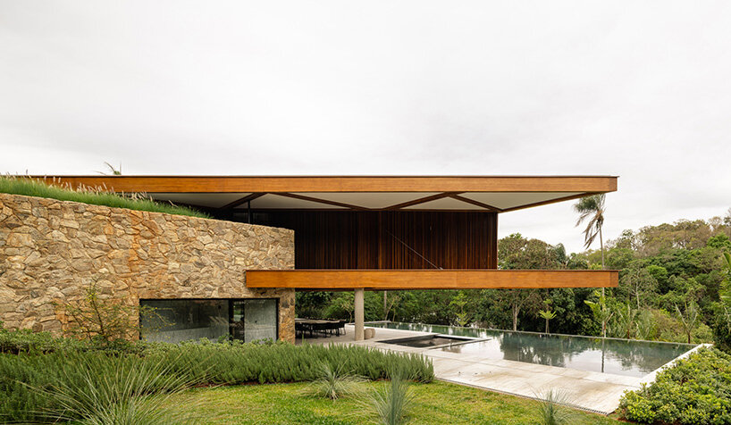 TETRO's lakeside residence in brazil vanishes into the horizon beneath triangular timber roof