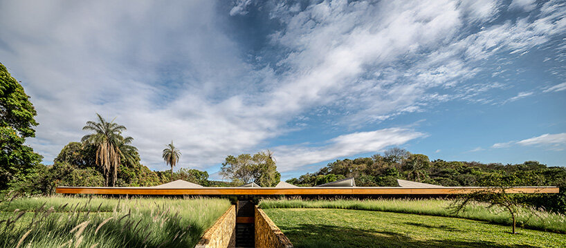 TETRO's lakeside residence in brazil vanishes into the horizon beneath triangular timber roof