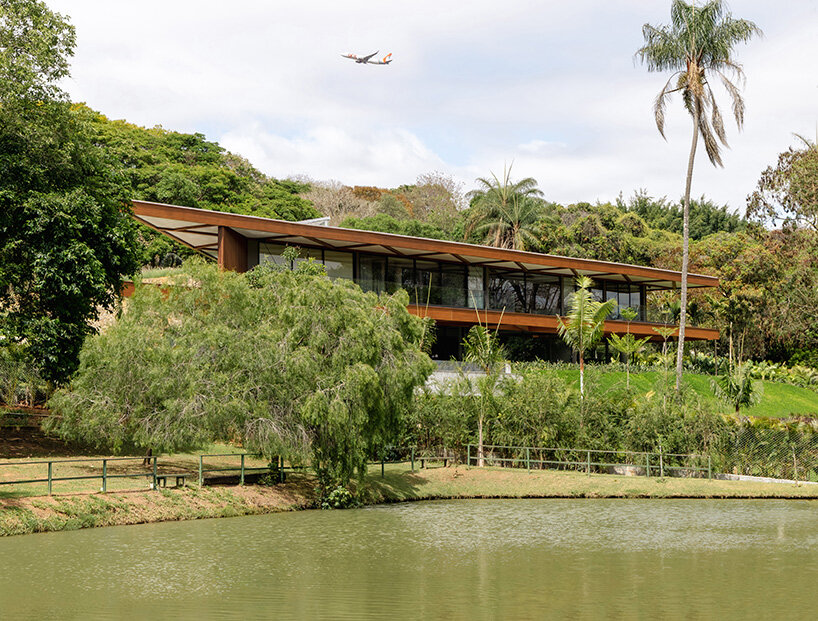 TETRO's lakeside residence in brazil vanishes into the horizon beneath triangular timber roof