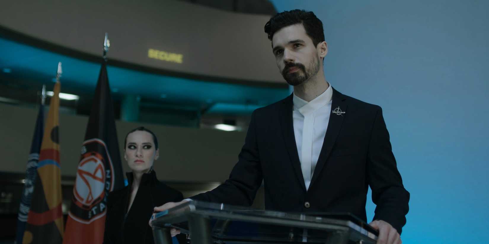 Holden on the podium as Drummer looks on in The Expanse