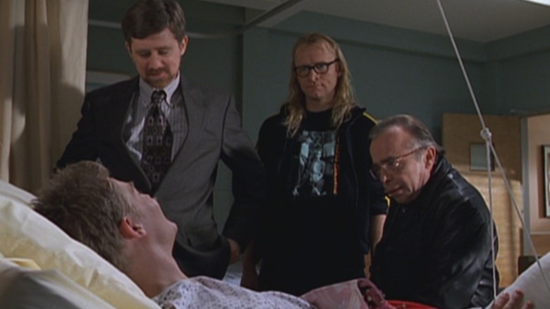 John Fitzgerald Byers (Bruce Harwood), Melvin Frohike (Tom Braidwood), and Richard Langly (Dean Haglund) speak to a man in the hospital in The Lone Gunmen