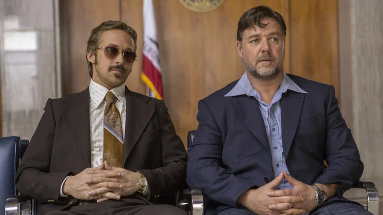 Holland March (Ryan Gosling) and Jackson Healy (Russell Crowe) sit next to each other in a government building in The Nice Guys