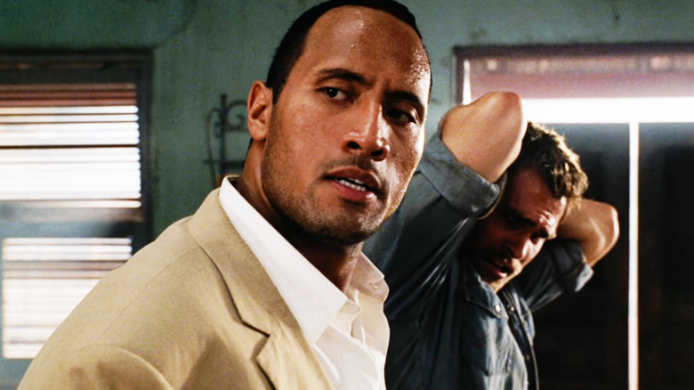 Beck (Dwayne Johnson) grabs Travis Walker (Seann William Scott) by his collar in The Rundown