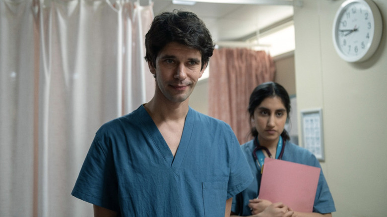 Adam Kay (Ben Whishaw) smiles bemused behind a medical curtain in This Is Going to Hurt