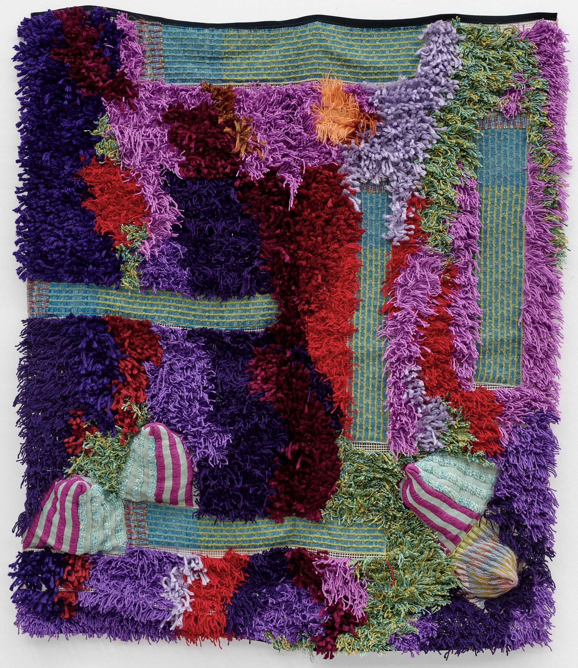 An abstract, tufted wall tapestry artwork by Sarah Zapata in primarily magenta, red, purple, and green