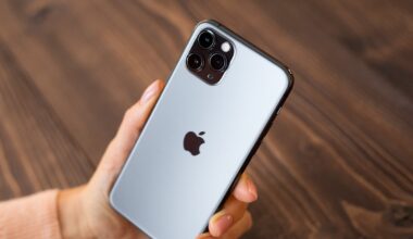 A hand holding an iPhone showing the Apple logo.