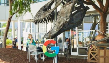 Google's logo hanging from a dinosaur skeleton.