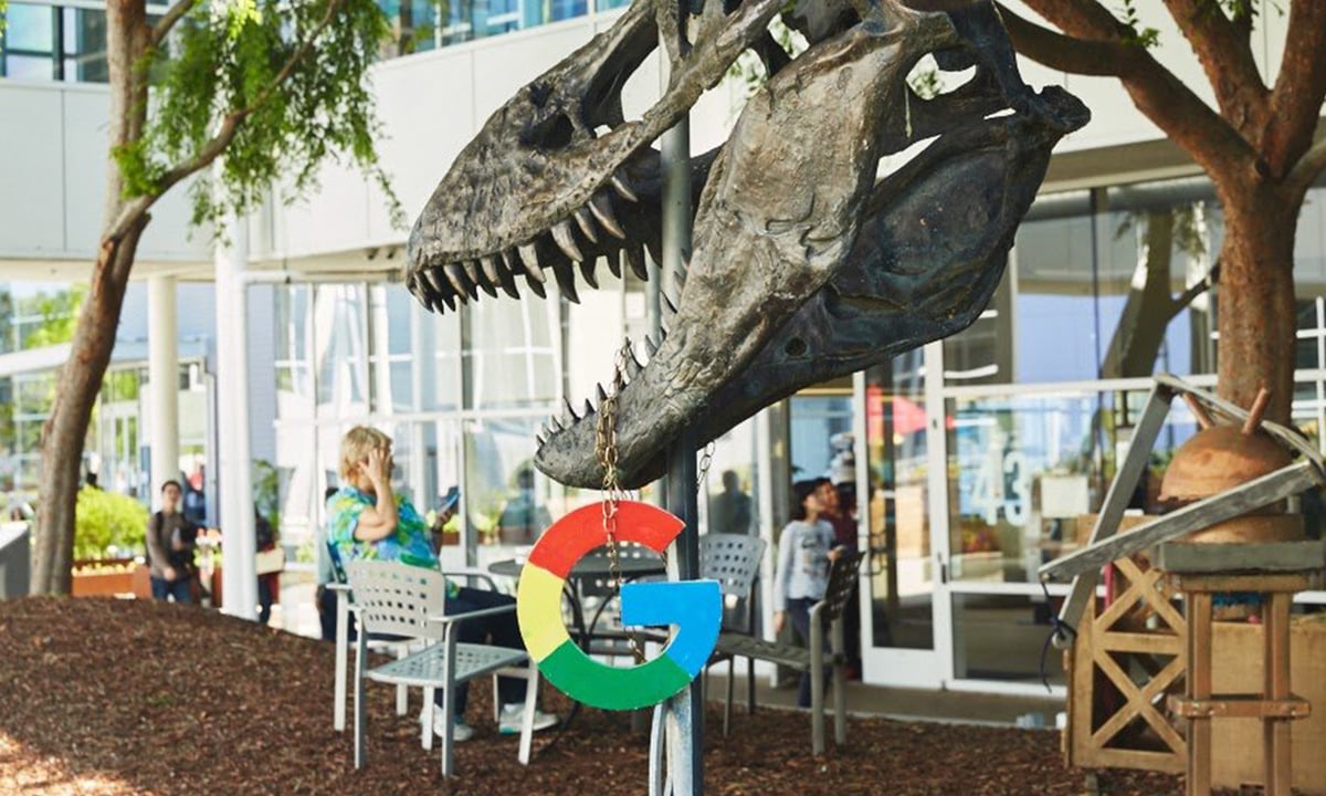 Google's logo hanging from a dinosaur skeleton.