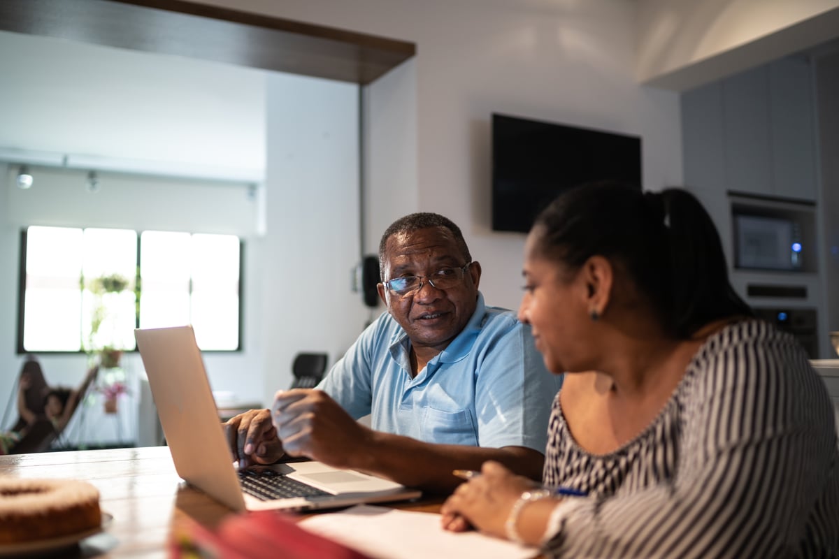 A couple evaluating their financial situation with the help of a laptop.