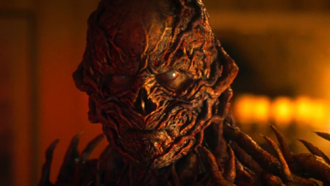 closeup of Vecna in full monster form bathed in ominous red /orange light