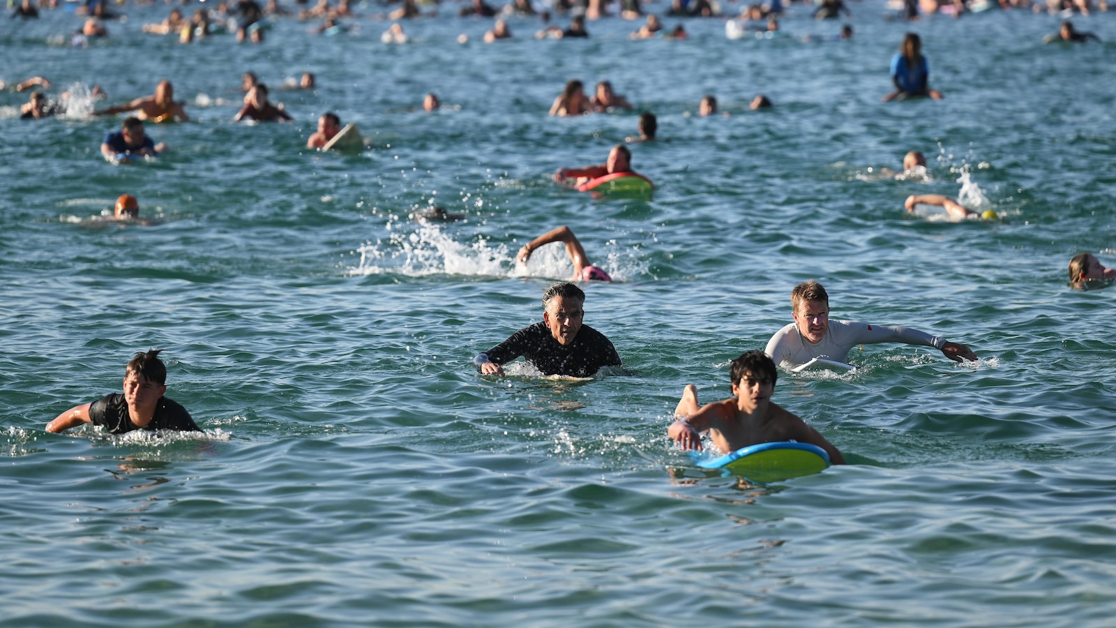 A sunrise crowd gathers at Bondi Beach in solace and defiance after a massacre
