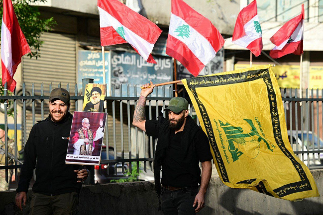 Hezbollah operatives waving the organization's flags and pictures of Nasrallah and the Pope during the passage of the Pope's convoy in the Dahiyeh al-Janoubia (Telegram channel South Lebanon–Observer of the Enemy, November 30, 2025)