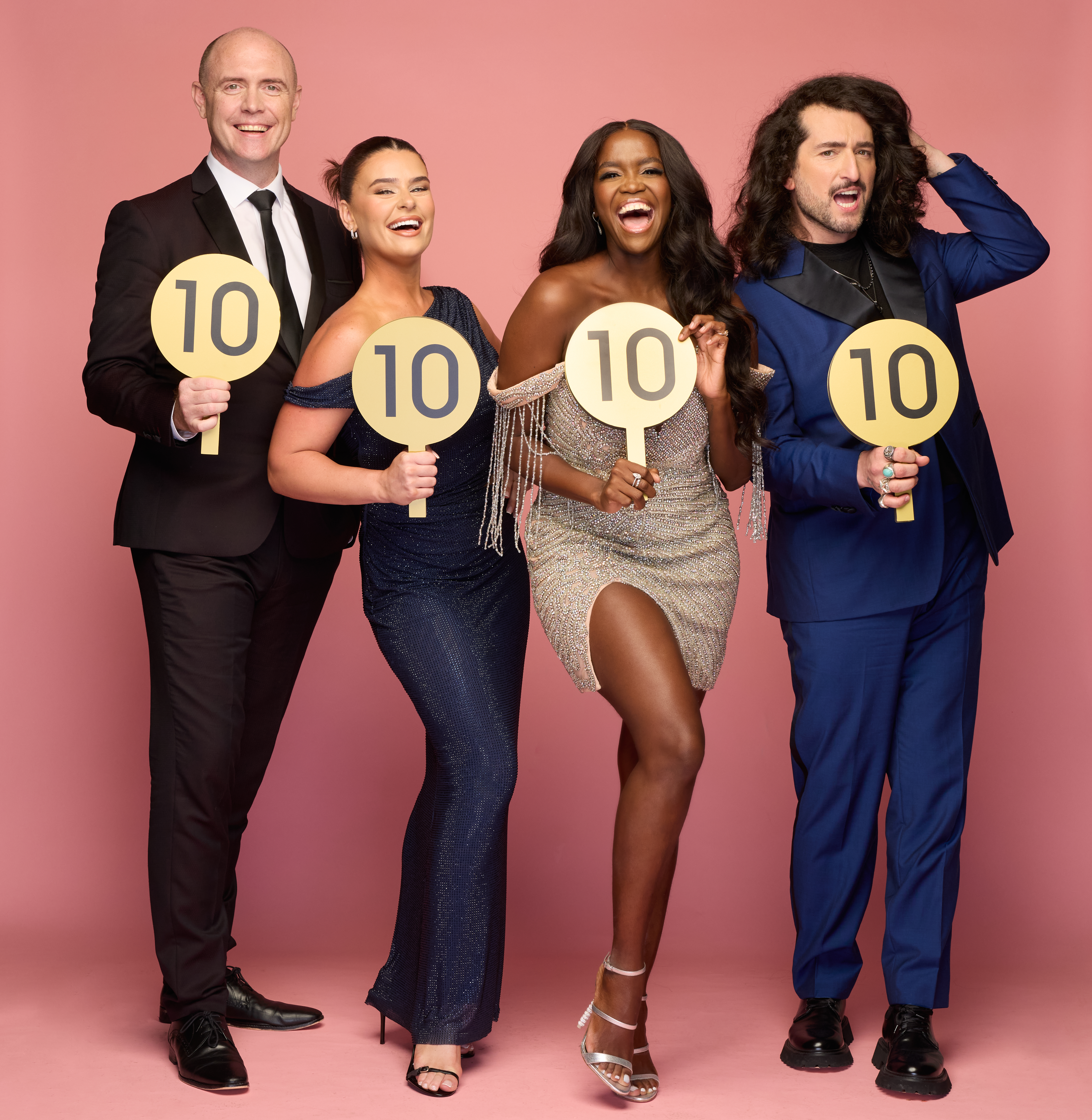Brian Redmond, Karen Byrne, Oti Mabuse, and Arthur Gourounlian, from left to right, smiling and holding "10" score paddles.