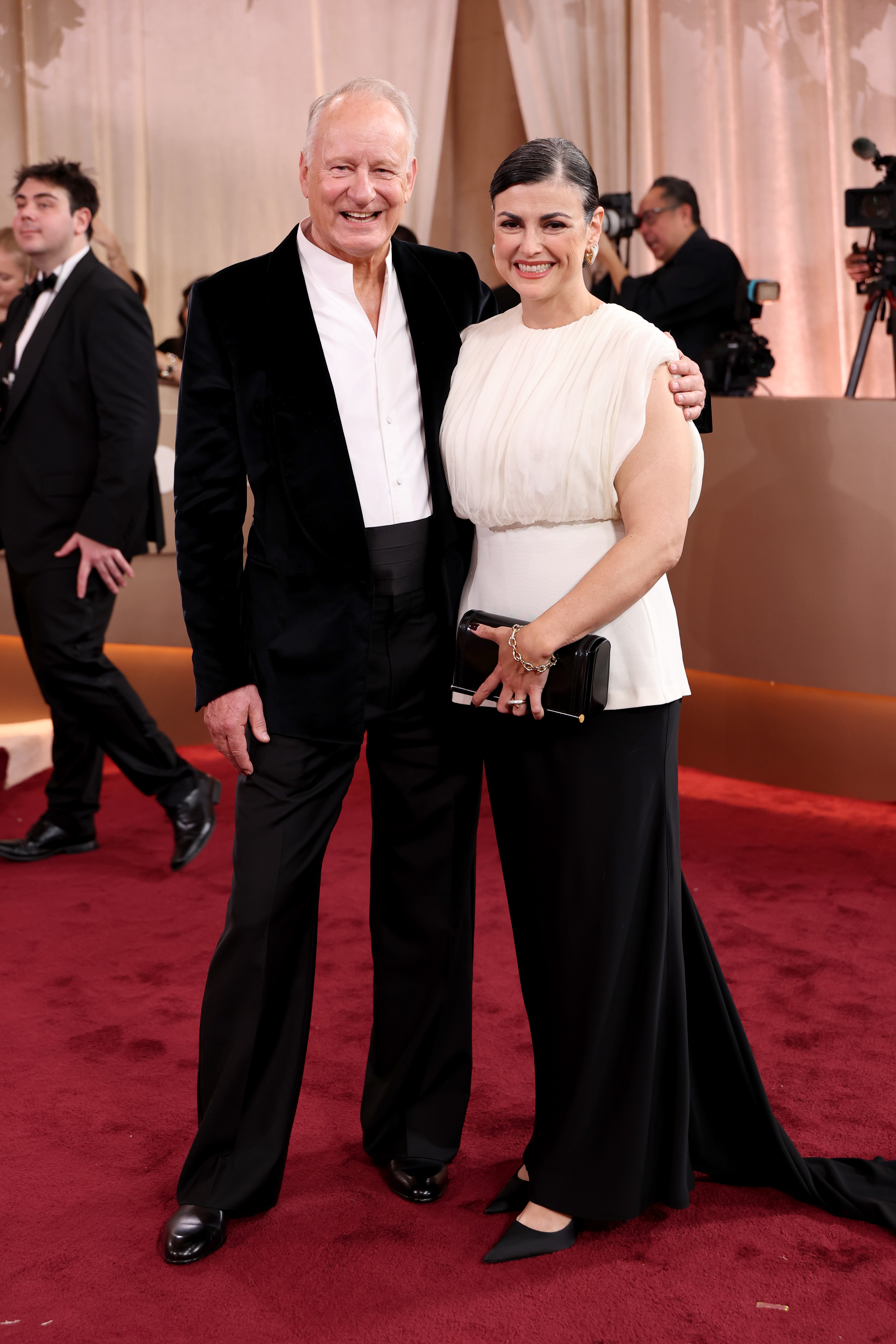 Stellan Skarsgård and Megan Everett-Skarsgård posing on the red carpet at the 83rd Annual Golden Globe Awards.