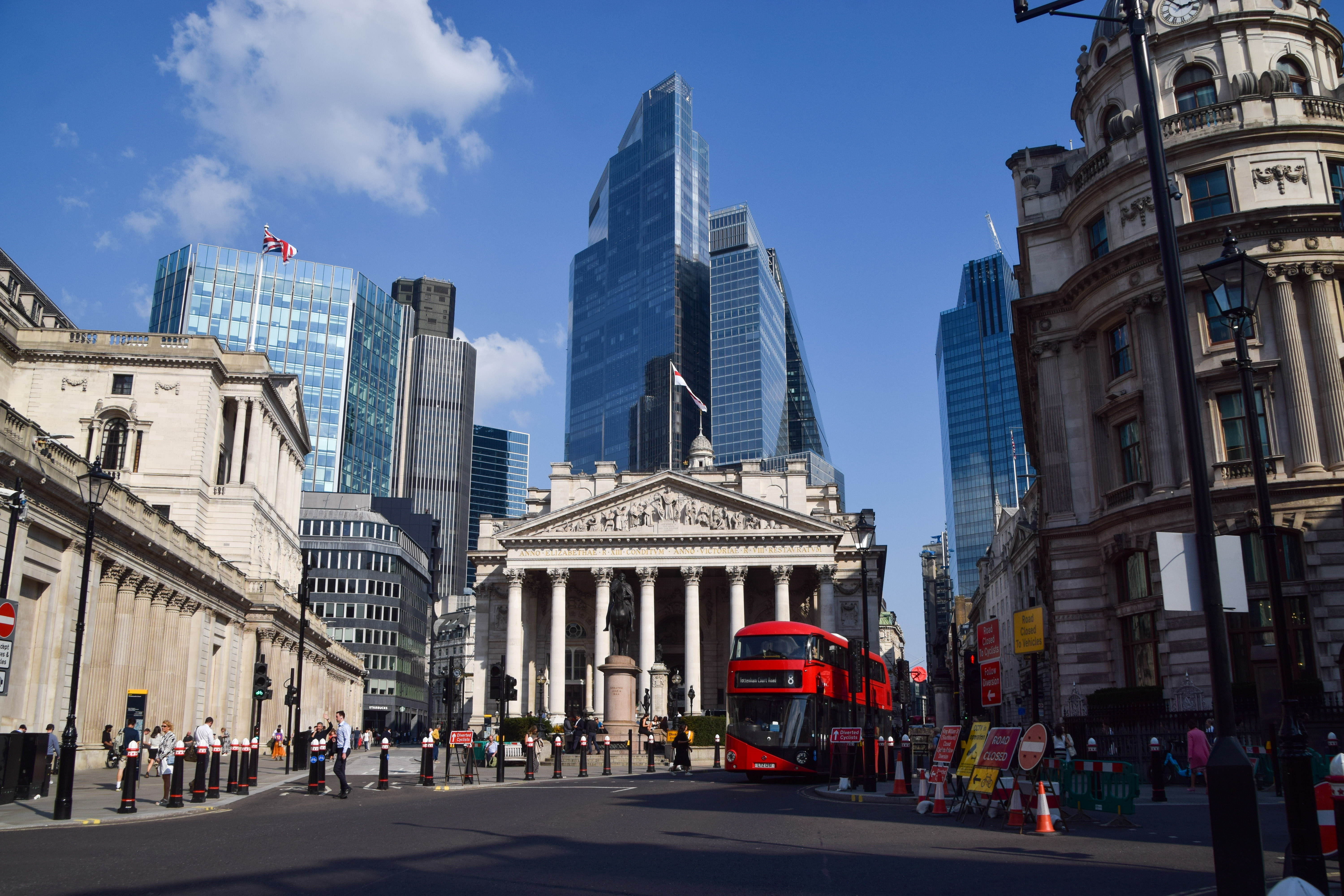 Daytime view of the Bank of England, the Royal Exchange and the City of London skyline at Bank Junction with a red double-decker bus.