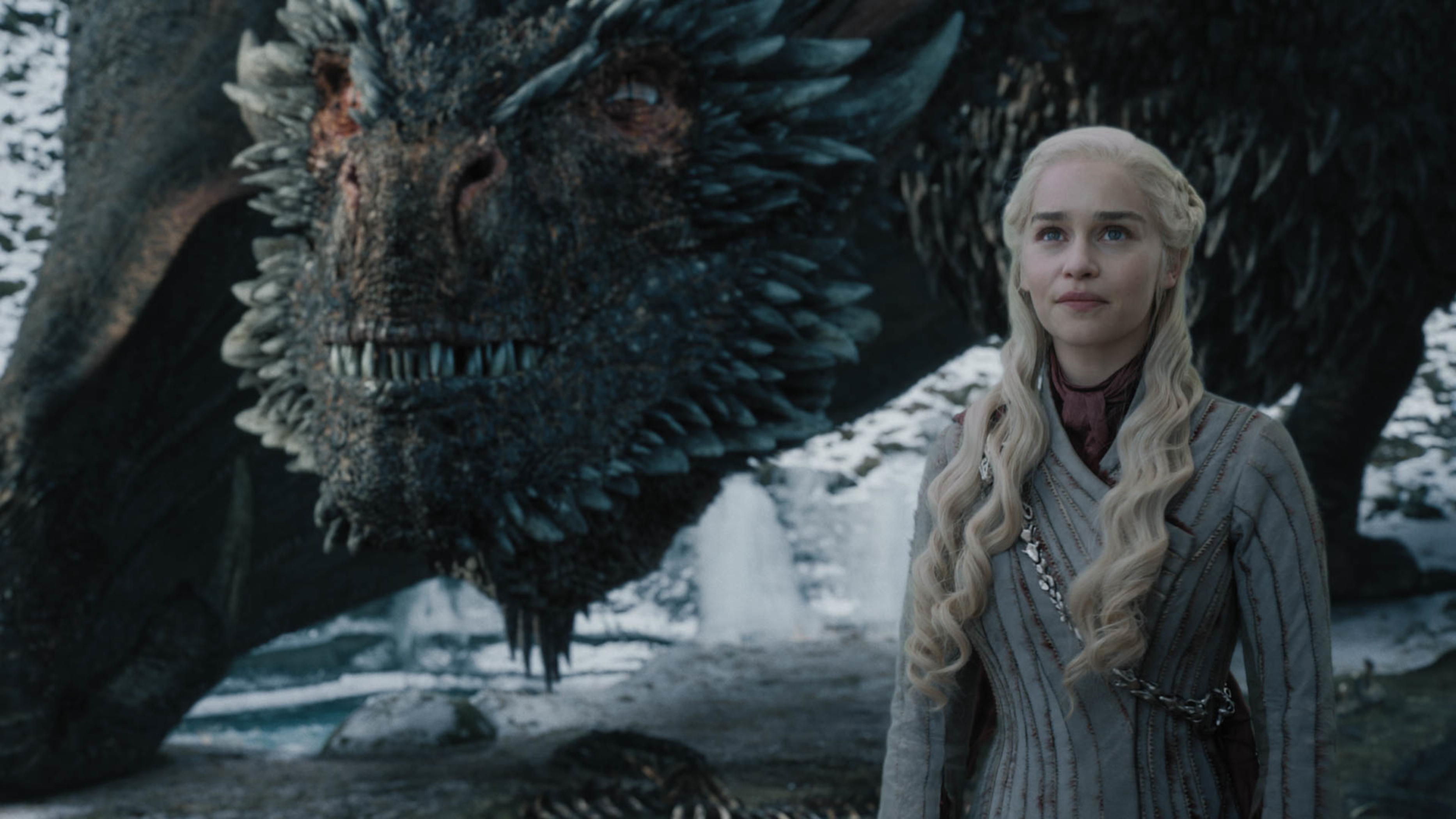 Daenerys Targaryen stands in front of a dragon in a scene from "Game of Thrones".