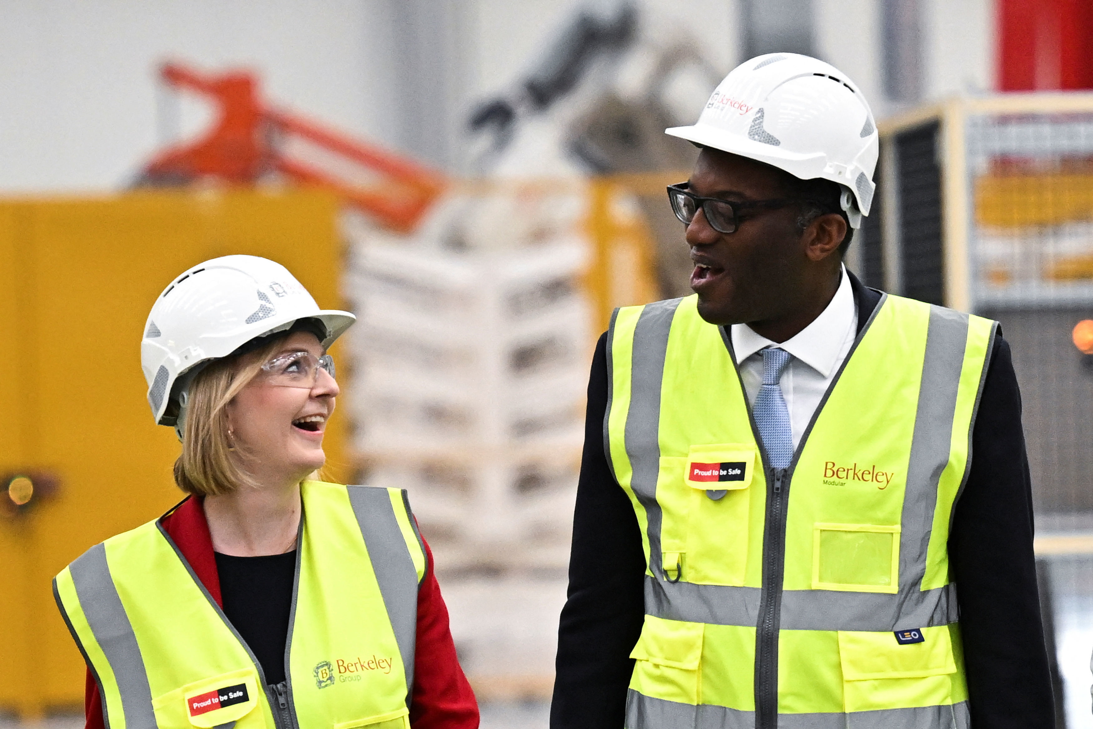 Prime Minister Liz Truss and Chancellor of the Exchequer Kwasi Kwarteng wearing safety vests and hard hats.