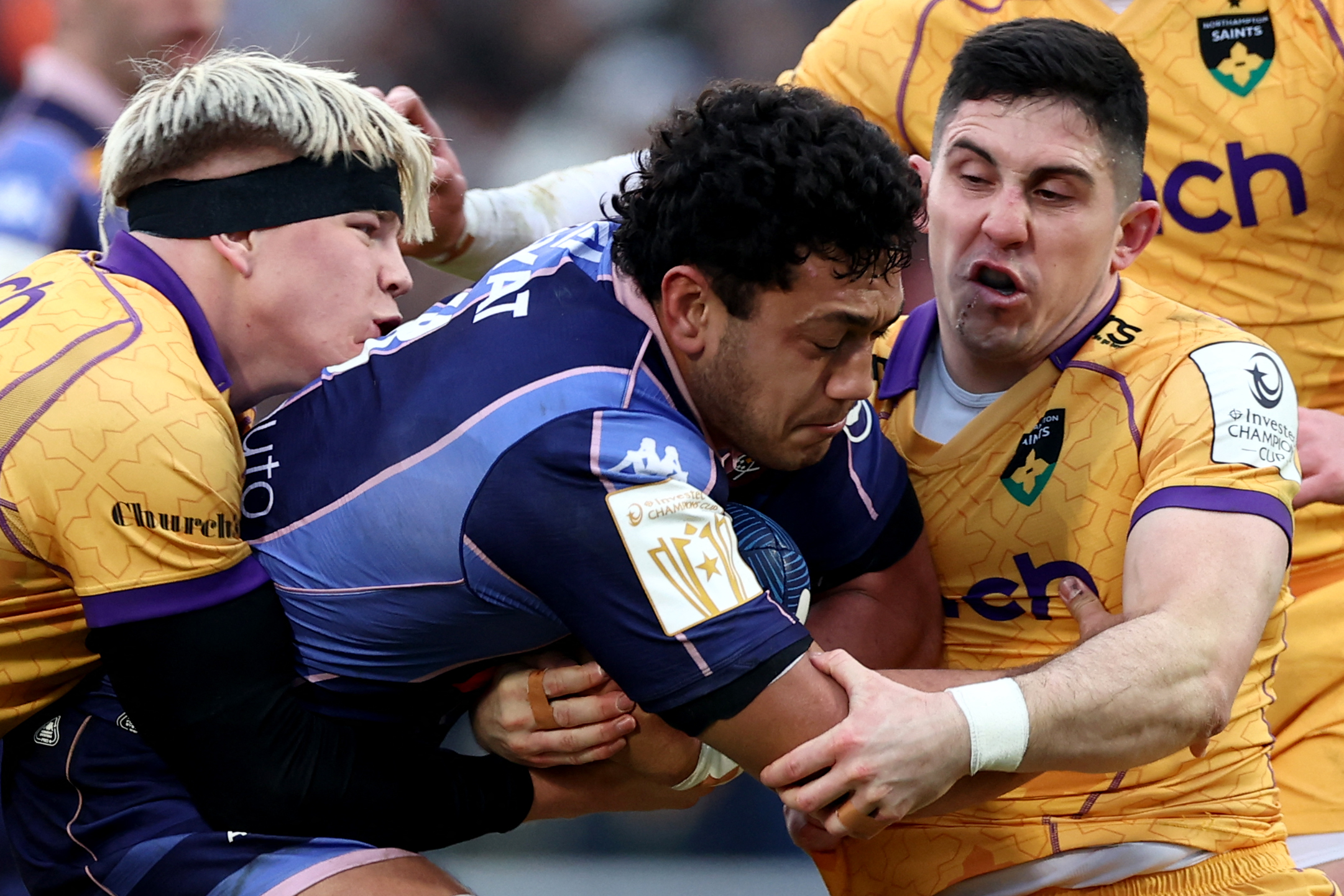 Bordeaux-Begles player Temo Matiu is tackled by Northampton Saints' Henry Pollock and Anthony Belleau during a rugby match.