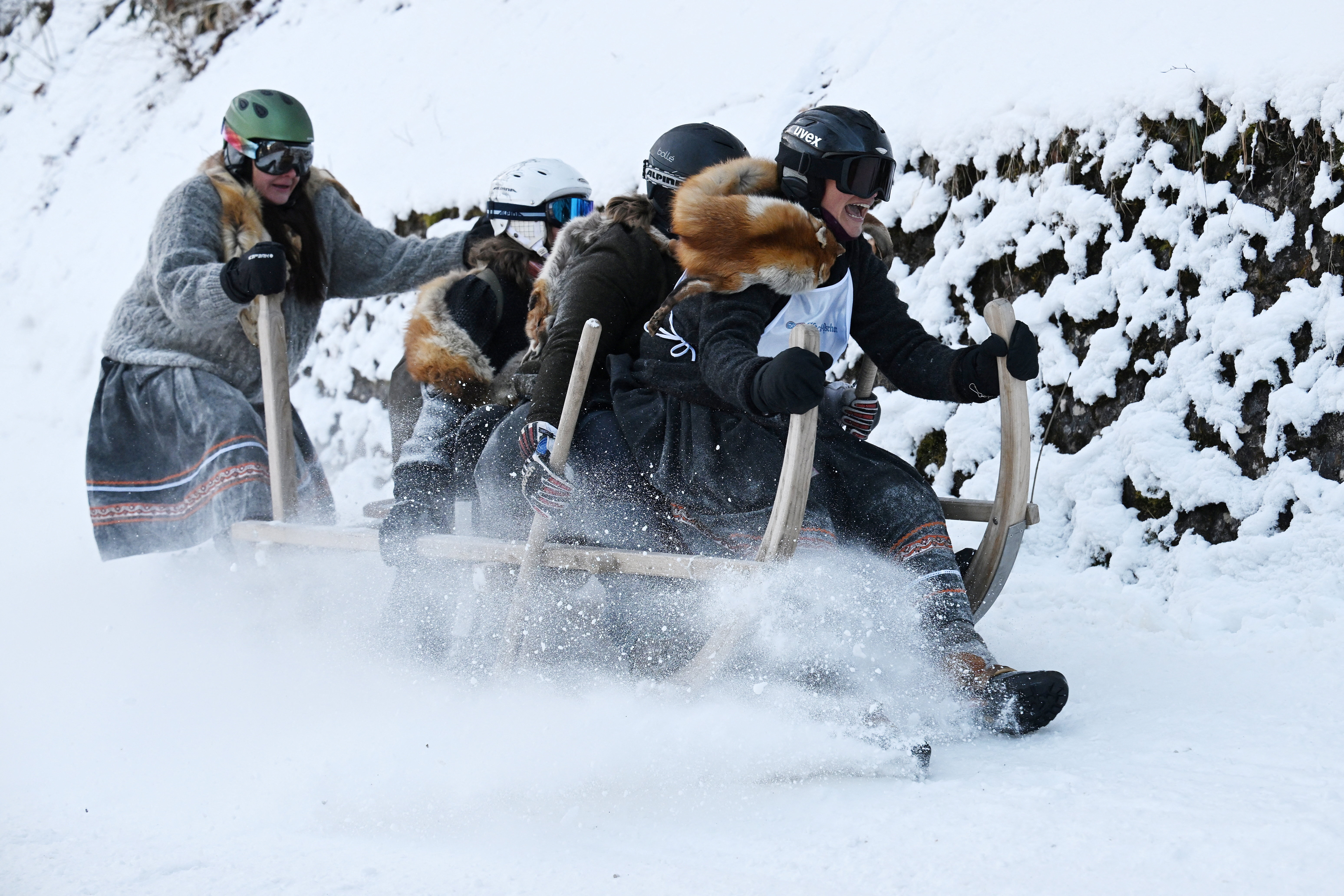 Competitors ride their wooden sledge during Hornschlittenrennen