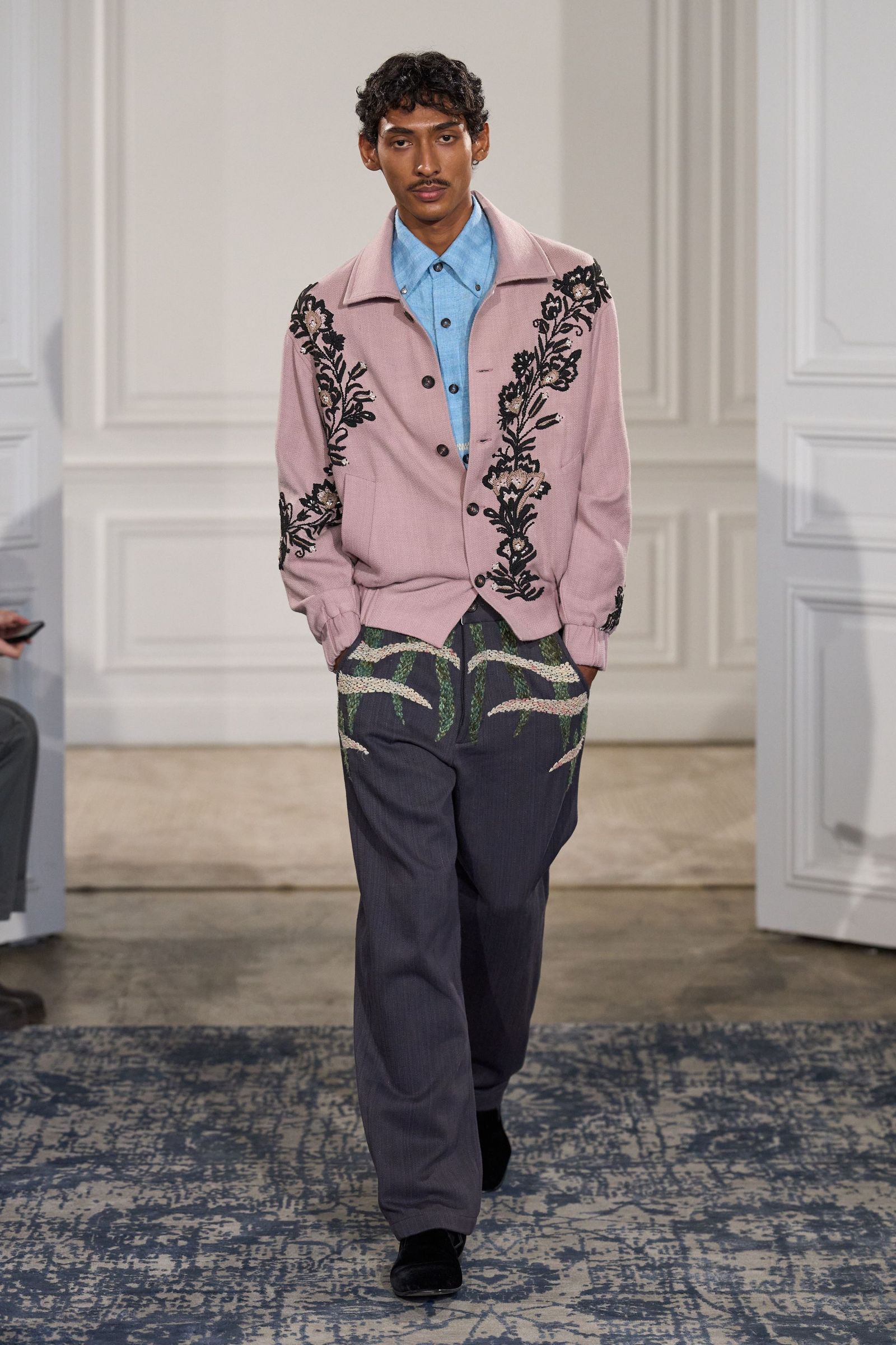 Image may contain Hrishikesh Pandey Blazer Clothing Coat Jacket Pants Formal Wear Suit Sleeve Person and Standing