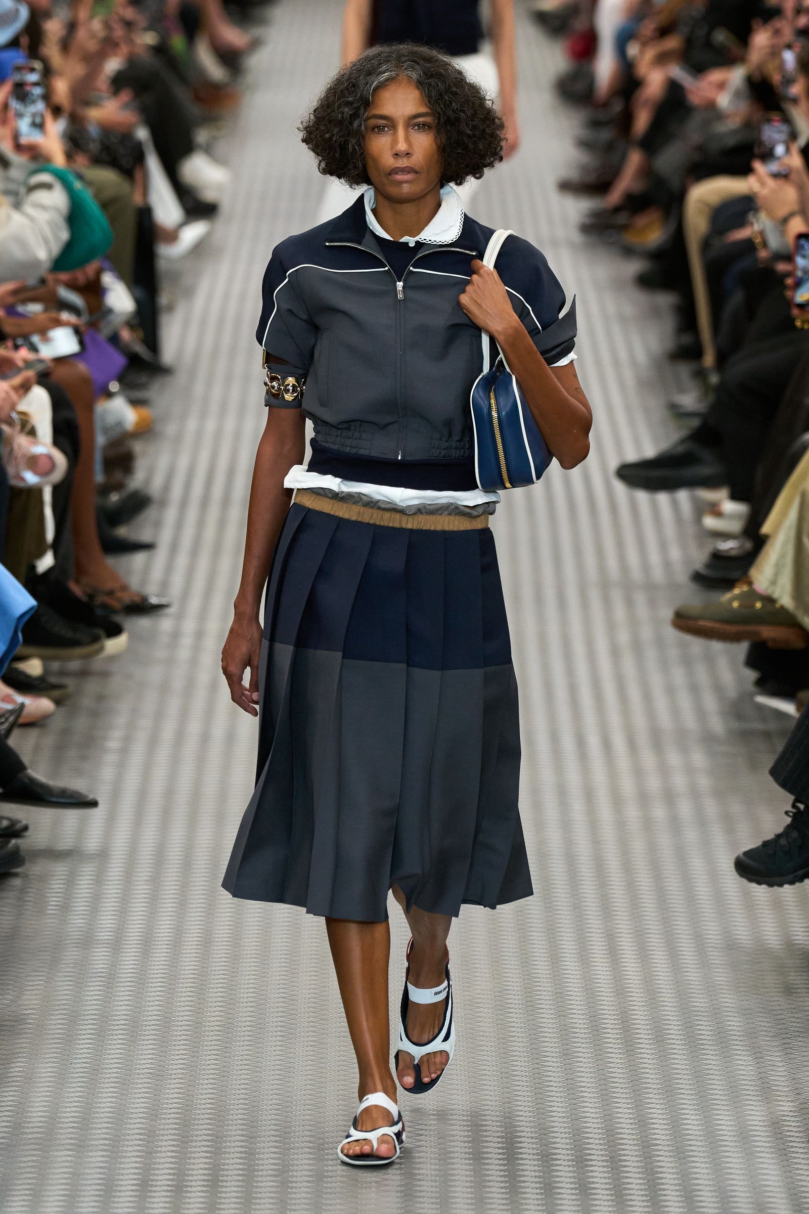 Image may contain Person Teen Clothing Footwear Sandal Accessories Bag Handbag Shoe Adult Skirt and Electronics