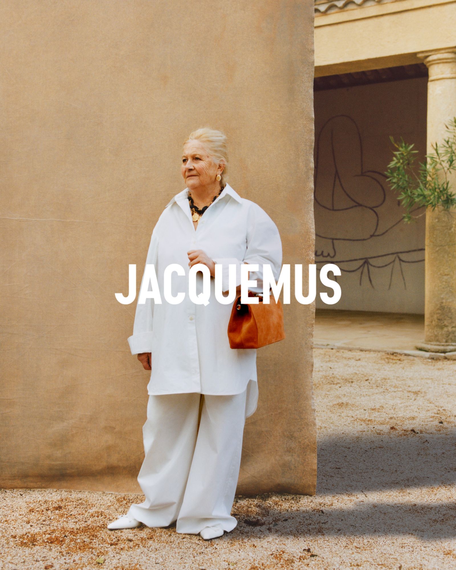 Image may contain Mary Peters Clothing Coat Person Walking Photography Accessories Bag Handbag Adult and Face