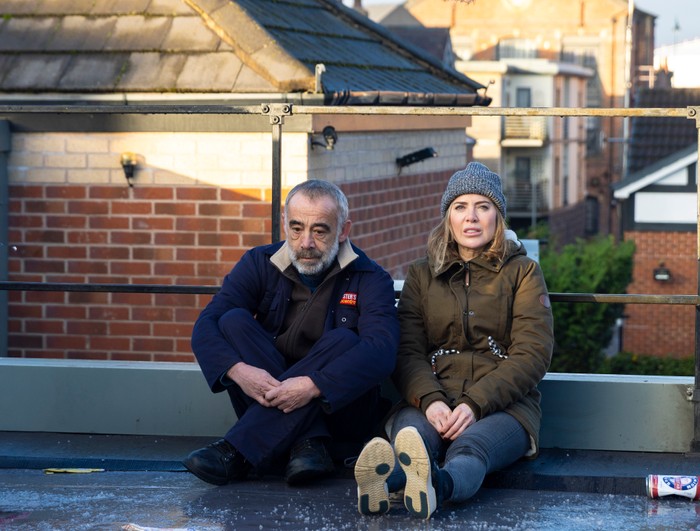 Kevin and Abi sat on the roof of Webster's Autocentre with a view of Victoria Street behind them in Coronation Street