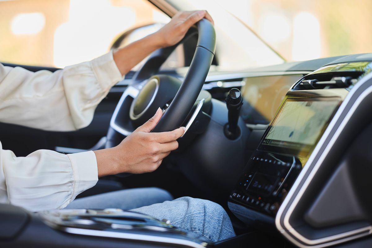 Close-up of woman's hands driving car