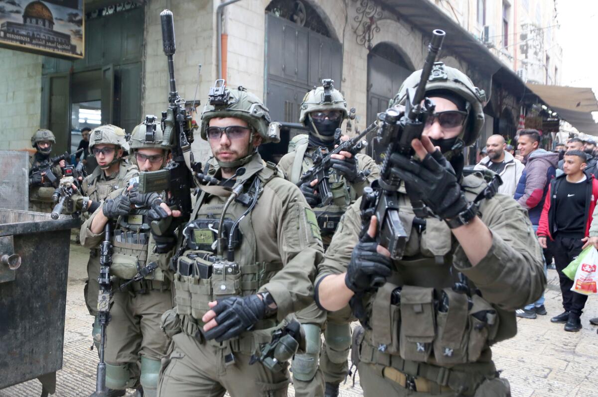 Israeli soldiers aim their rifles during a security operation