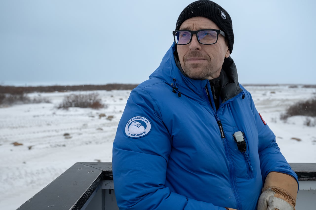 man in blue coat, toque and glasses
